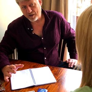 Mark Ryan WRITER, SITTING AT A TABLE FACING CLIENT INTERVIEWING.